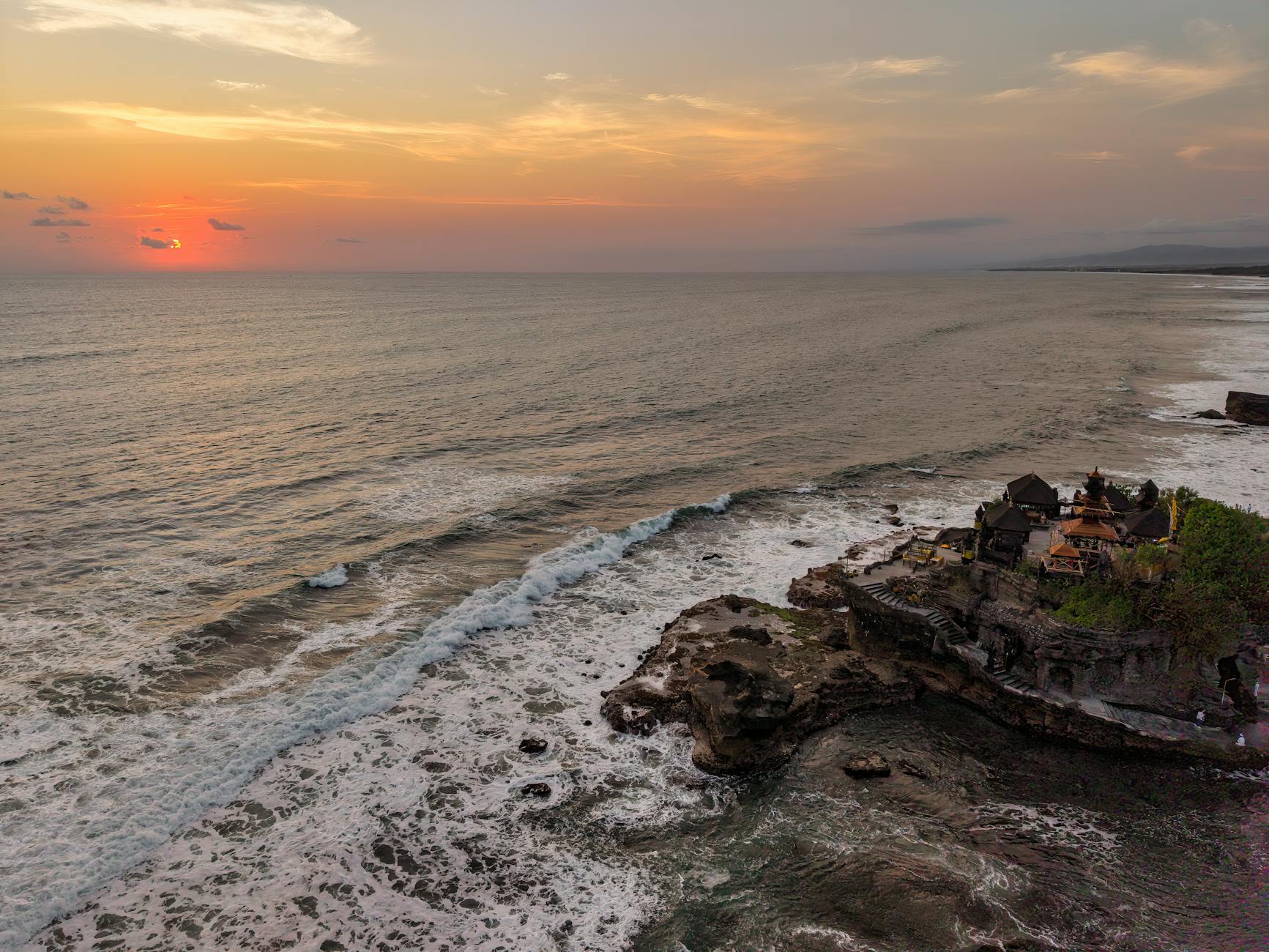 Tanah Lot temple Bali Indonesia clifftop ocean sunset aerial
