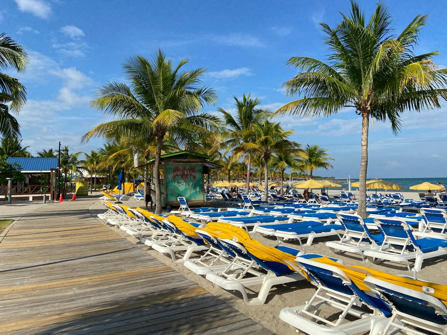 Belize Caribbean beach resort boardwalk palm trees sun loungers