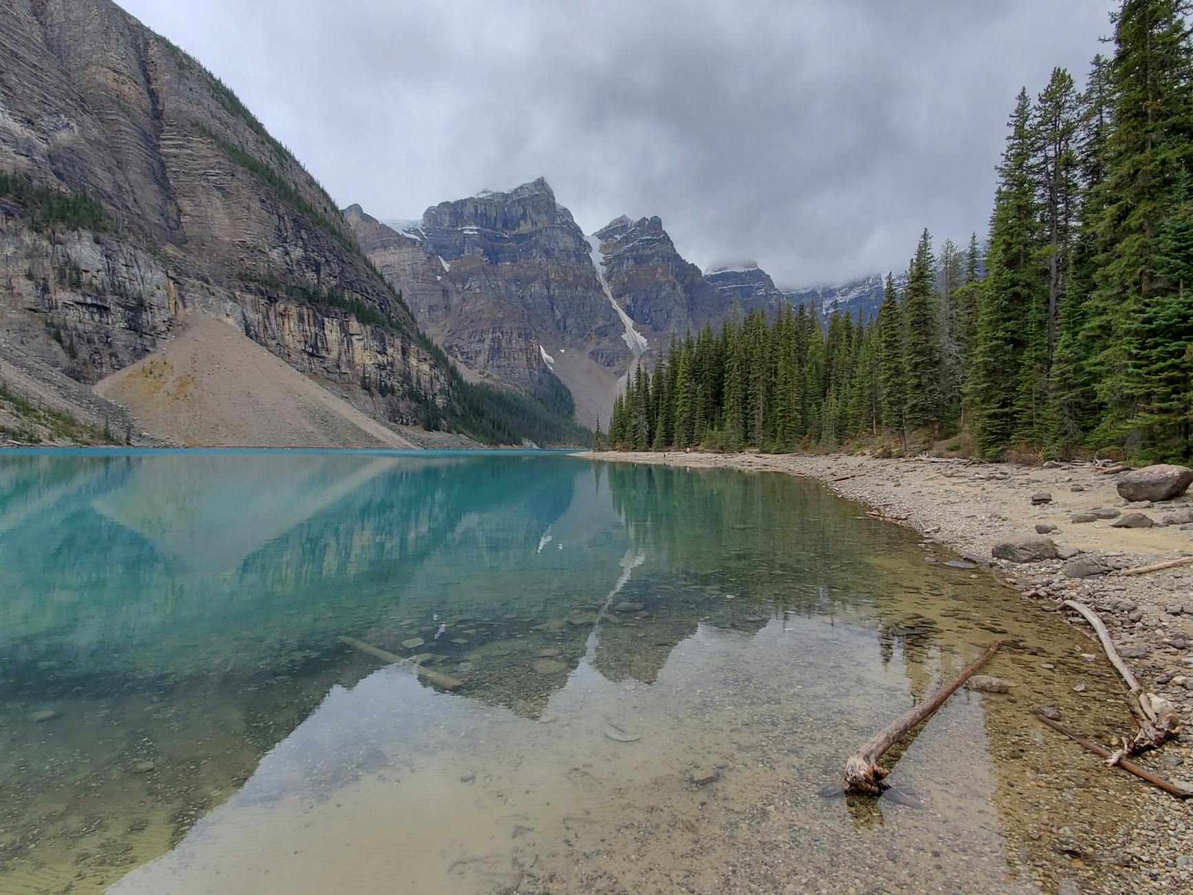 Capture the serene beauty of Moraine Lake with mountains reflected in clear turquoise water in Alberta, Canada.