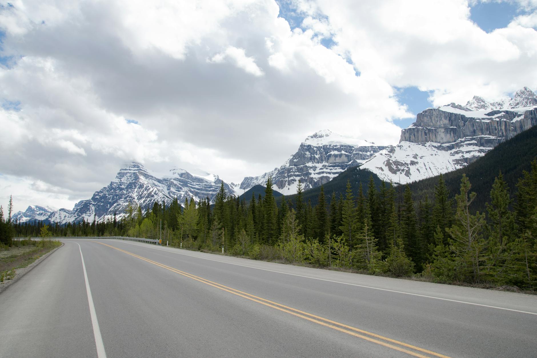 Enchanting view of a road leading into the snow-capped mountains of Alberta, Canada.
