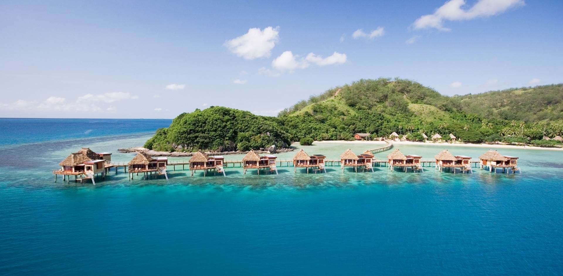 Fiji Likuliku Lagoon Resort overwater bungalows thatched roof turquoise lagoon