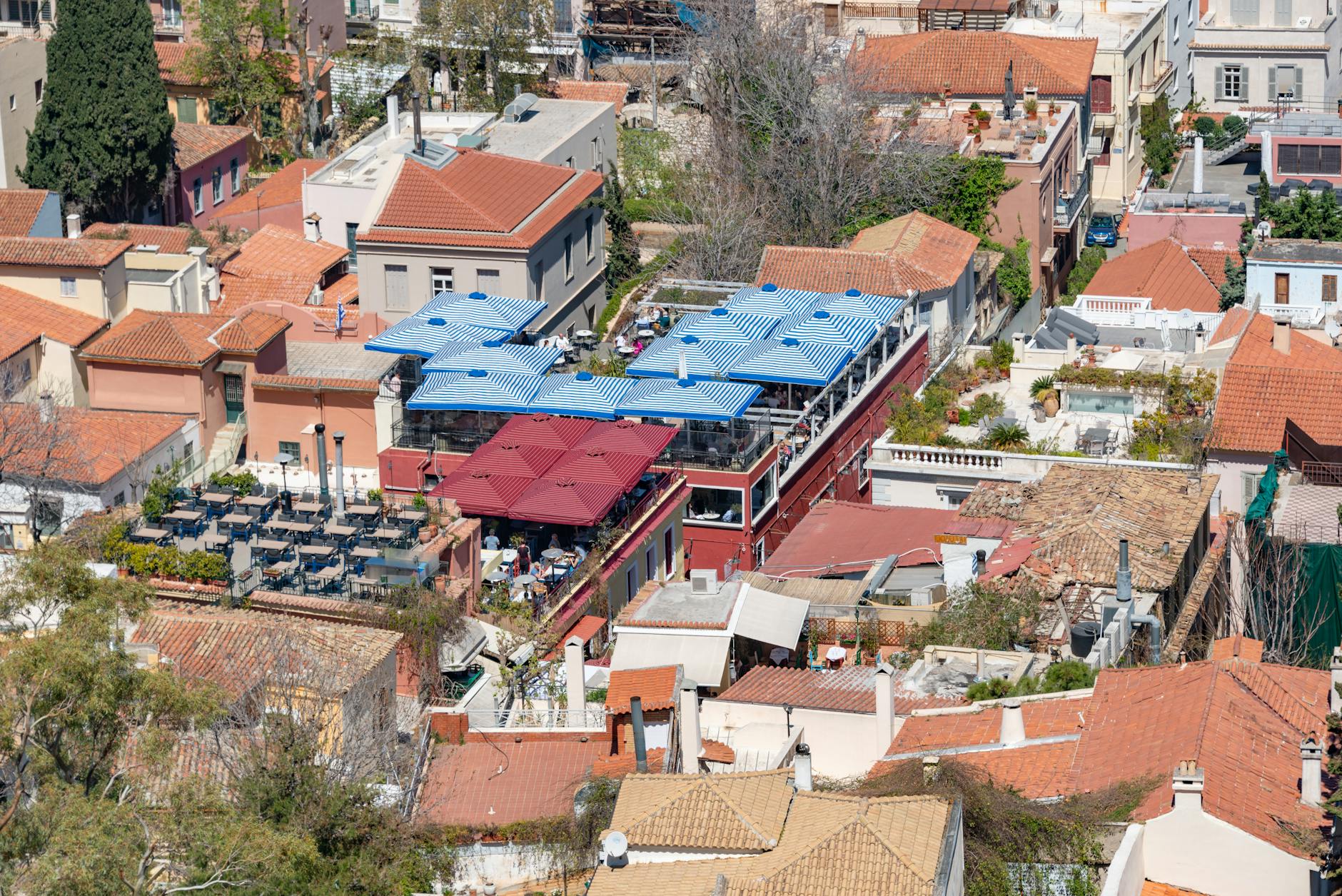 Athens Plaka neighbourhood rooftop terrace blue white umbrellas Acropolis view