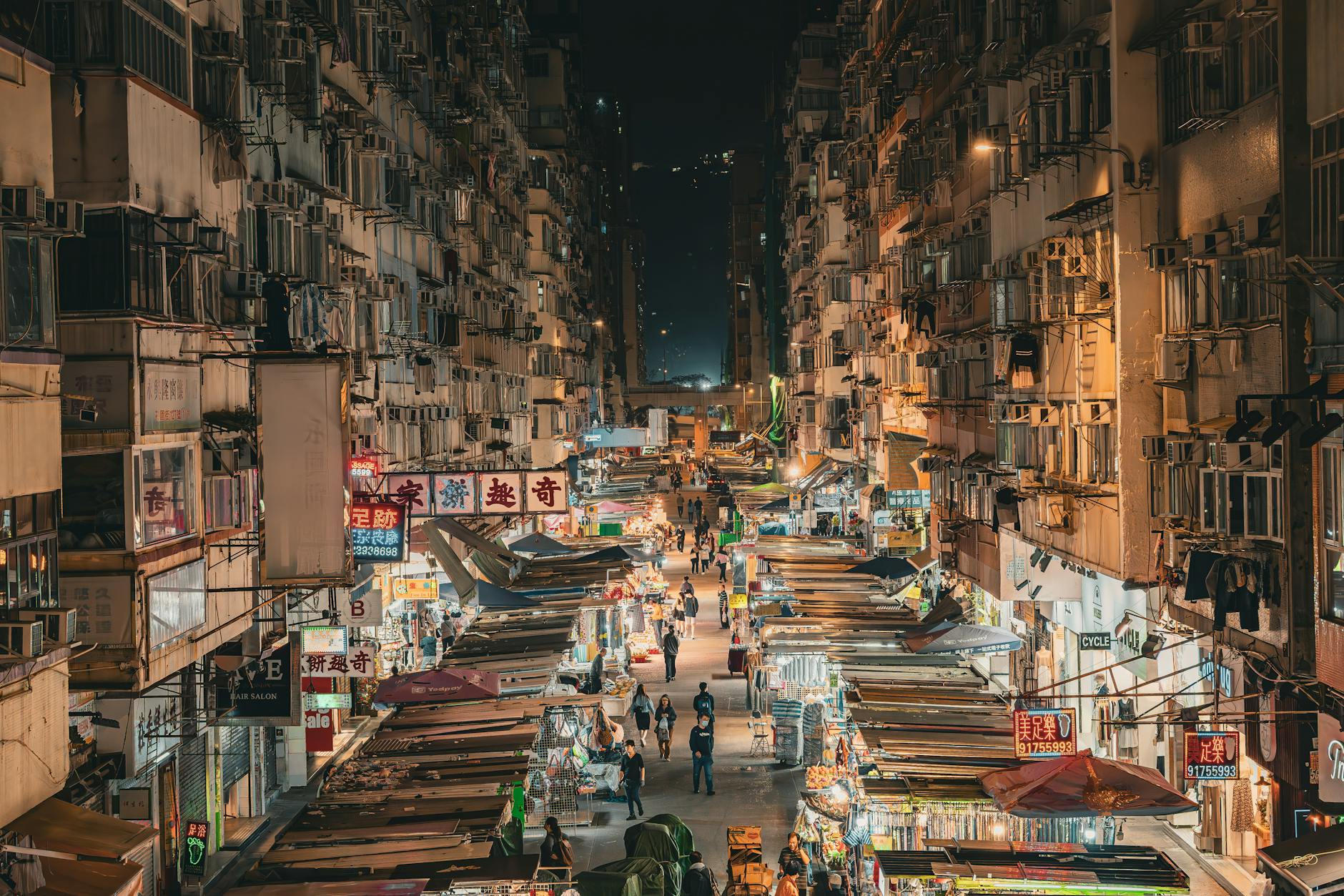 Hong Kong Mong Kok street market night aerial dense apartment blocks Chinese signs