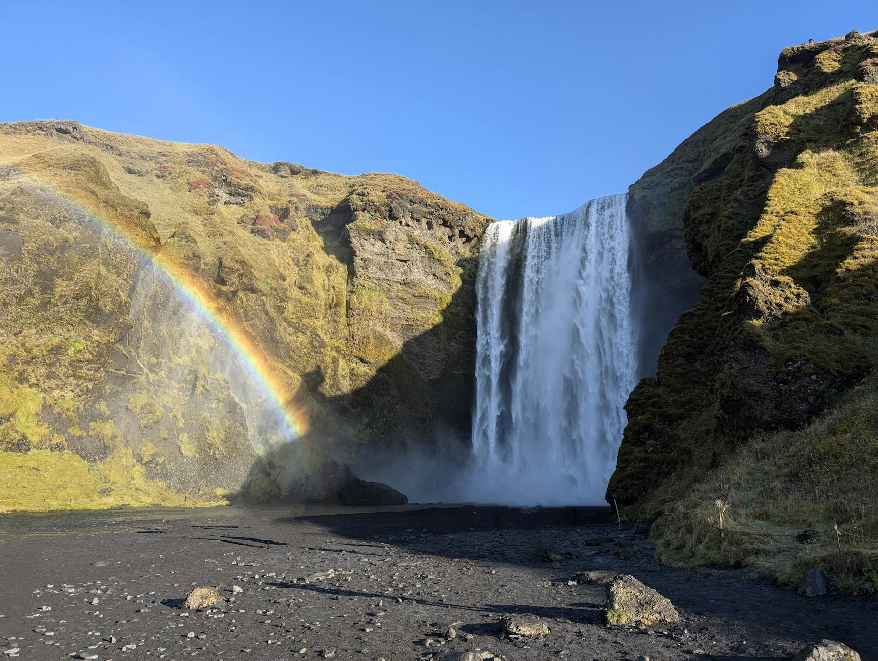 Skogafoss waterfall Iceland rainbow black sand blue sky