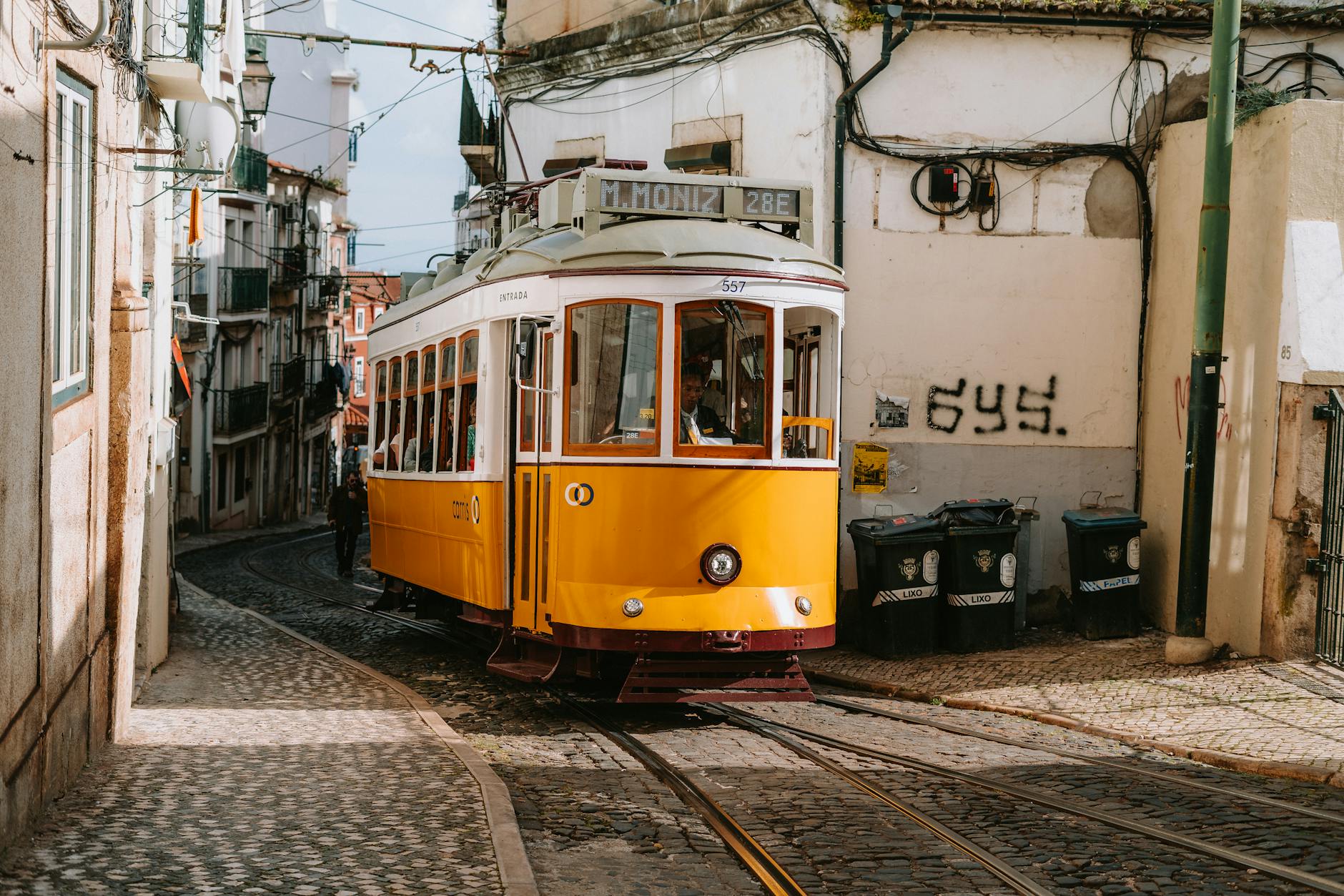 Tram 28E Lisbon Portugal yellow streetcar Alfama cobblestone street Martim Moniz