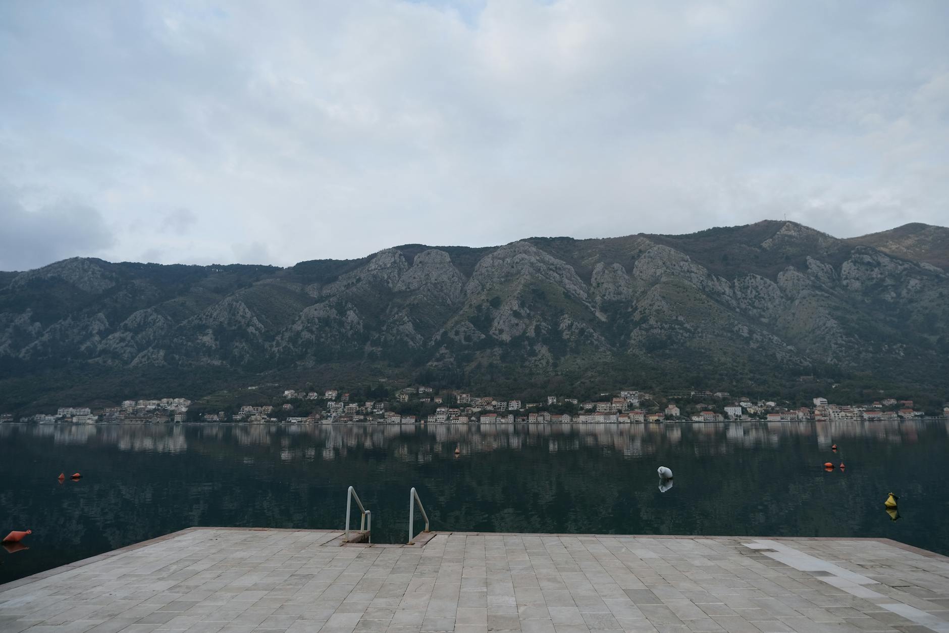 Kotor Bay Montenegro waterfront promenade calm water mountain reflection
