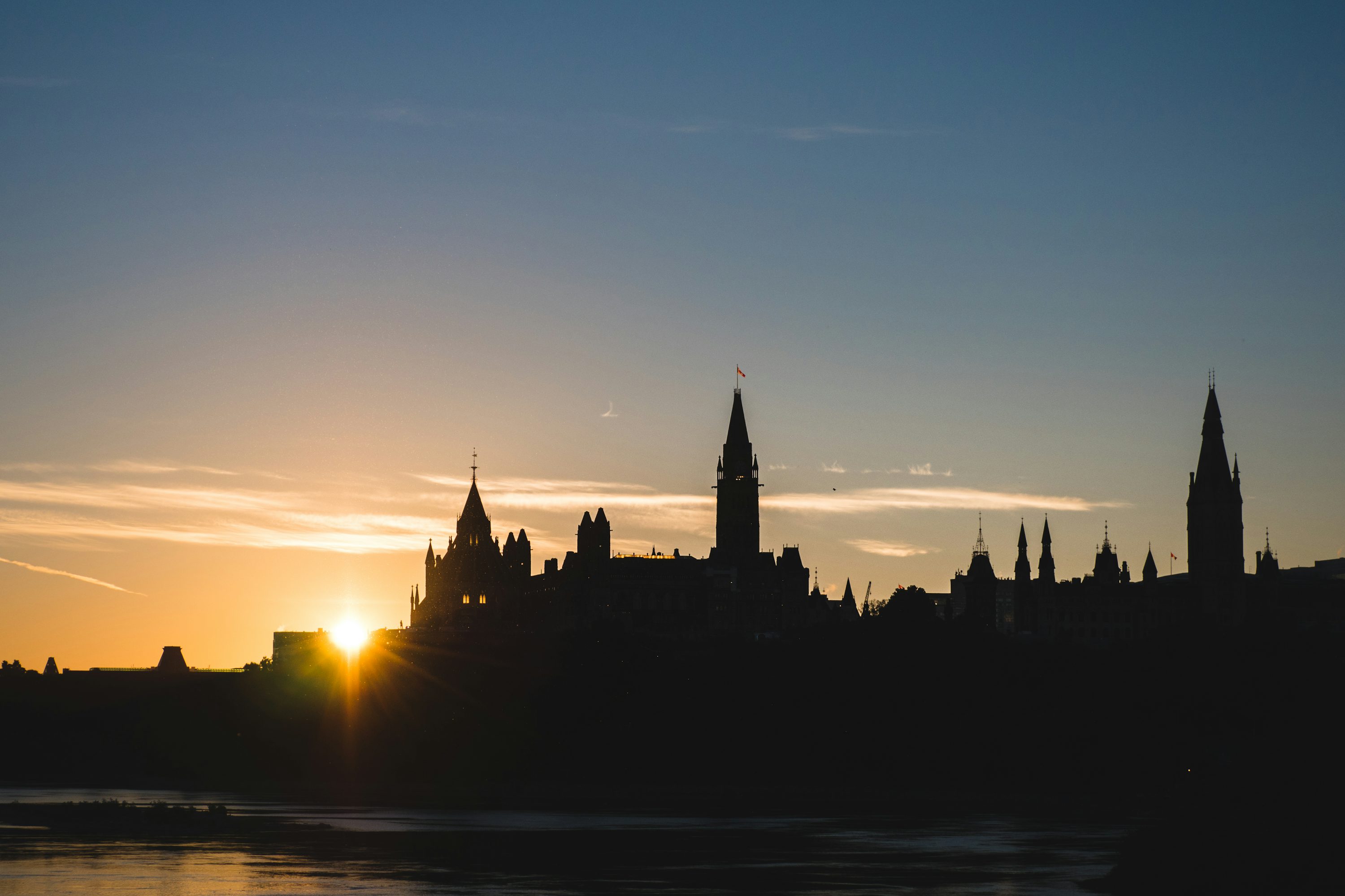 Ottawa Parliament Hill silhouette at sunset over Ottawa River Canada