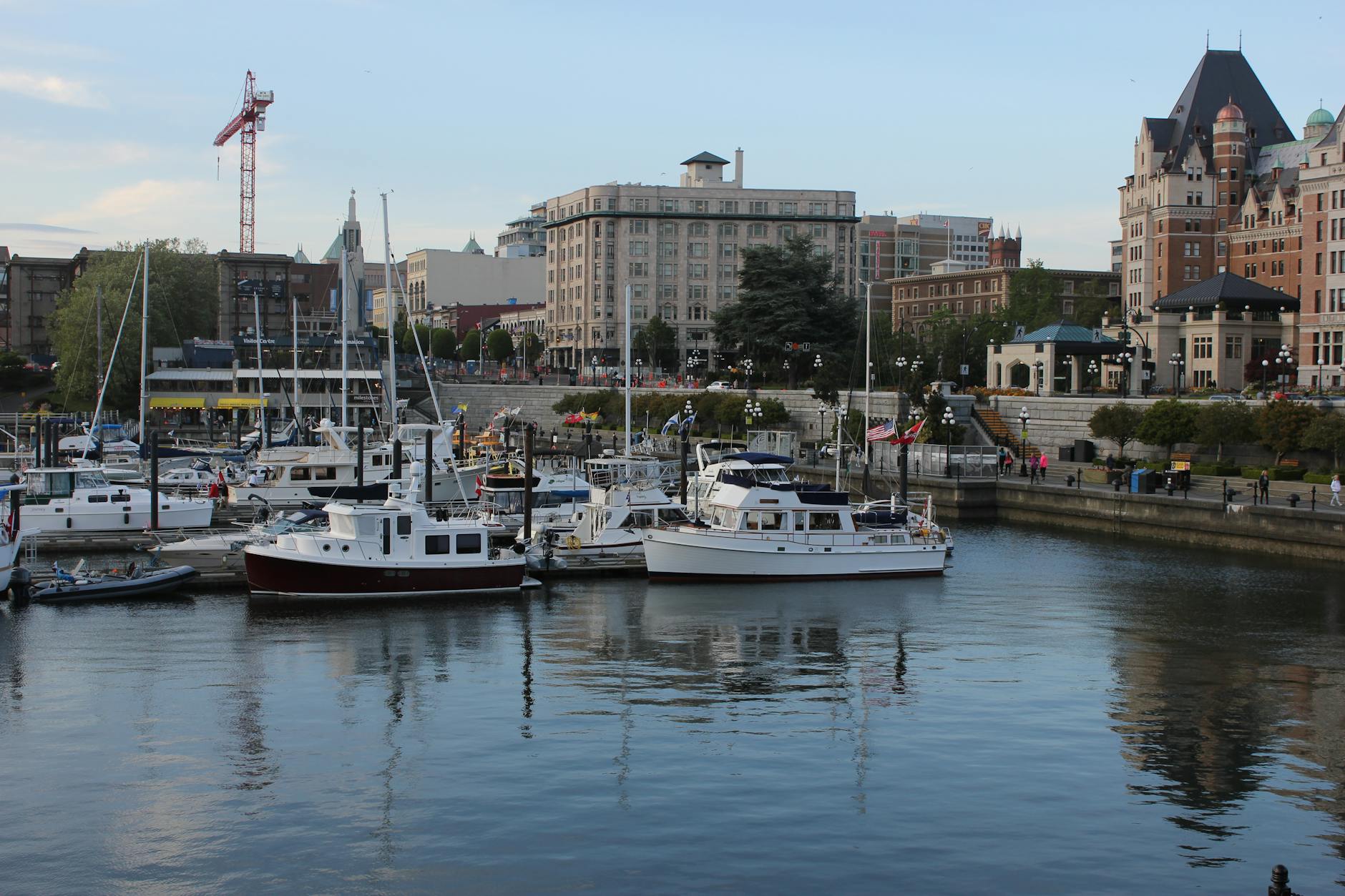 Scenic view of Victoria's bustling harbor with moored yachts and historic architecture.